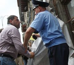 Міліціонер намагається завадити колишньому співвласнику магазина ”Сяйво” під час акції ”Корупційна стіна”